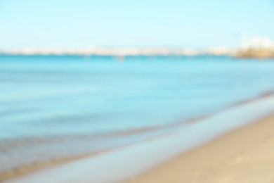 Photo of Beautiful sea and shore under light blue sky, blurred view