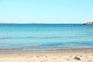 Photo of Beautiful sea and sandy beach under light blue sky