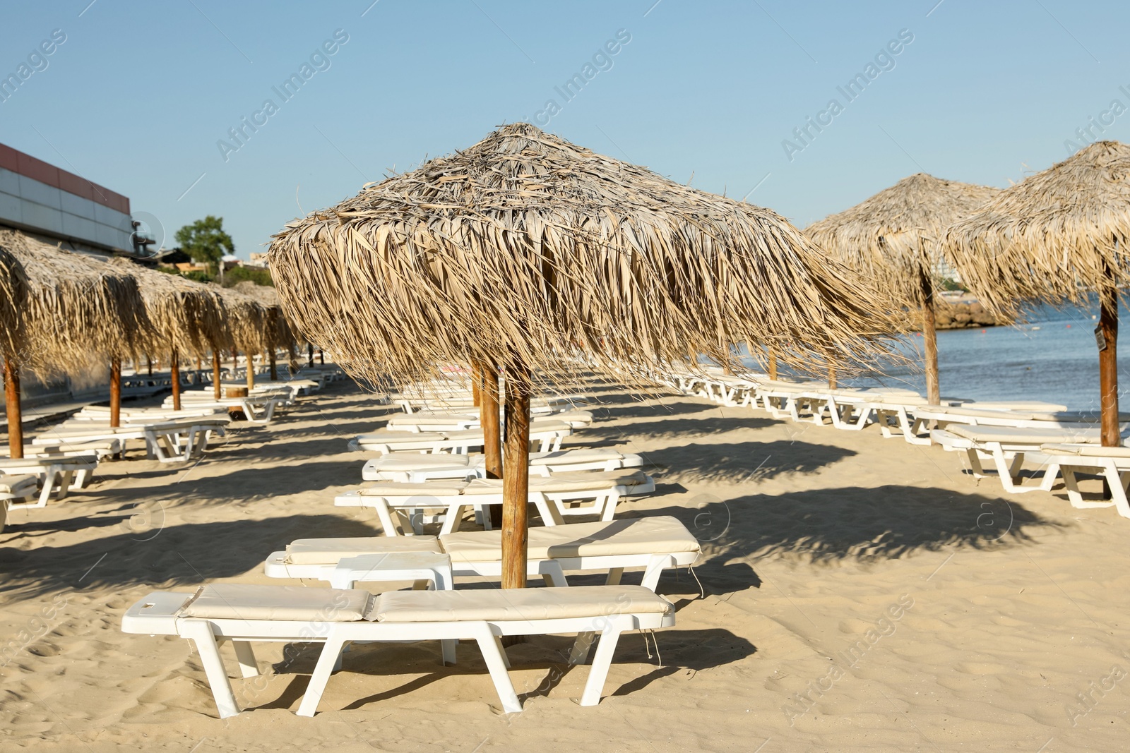 Photo of Straw umbrellas and sunbeds on sandy beach