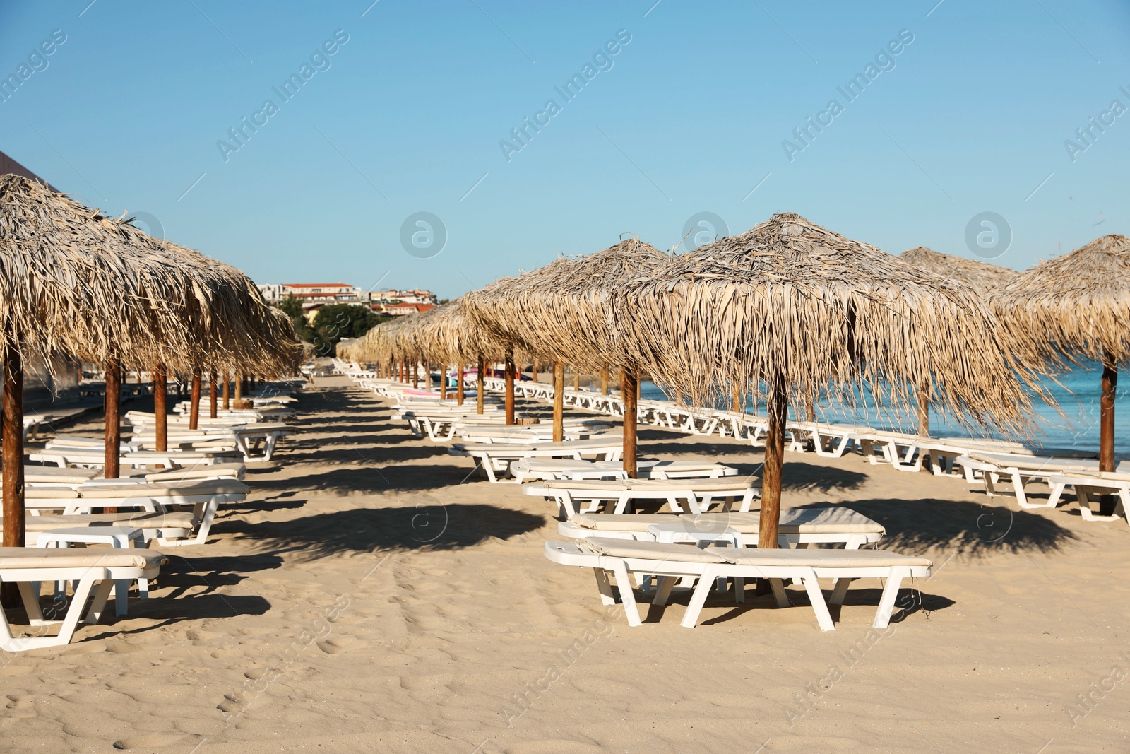 Photo of Straw umbrellas and sunbeds on sandy beach