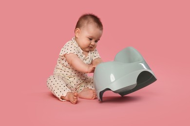 Photo of Cute little baby with potty on pink background
