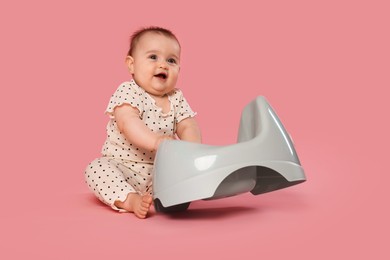 Photo of Cute little baby with potty on pink background