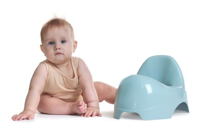 Photo of Cute little baby sitting near potty on white background