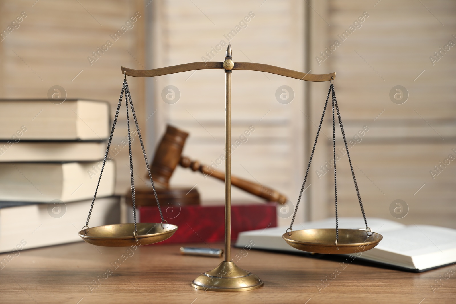 Golden scales of justice, gavel and books on wooden table Photo of Golden scales of justice, gavel and books on wooden table