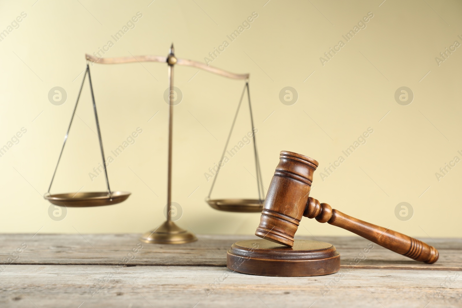 Golden scales of justice and gavel on wooden table against beige background, selective focus Photo of Golden scales of justice and gavel on wooden table against beige background, selective focus