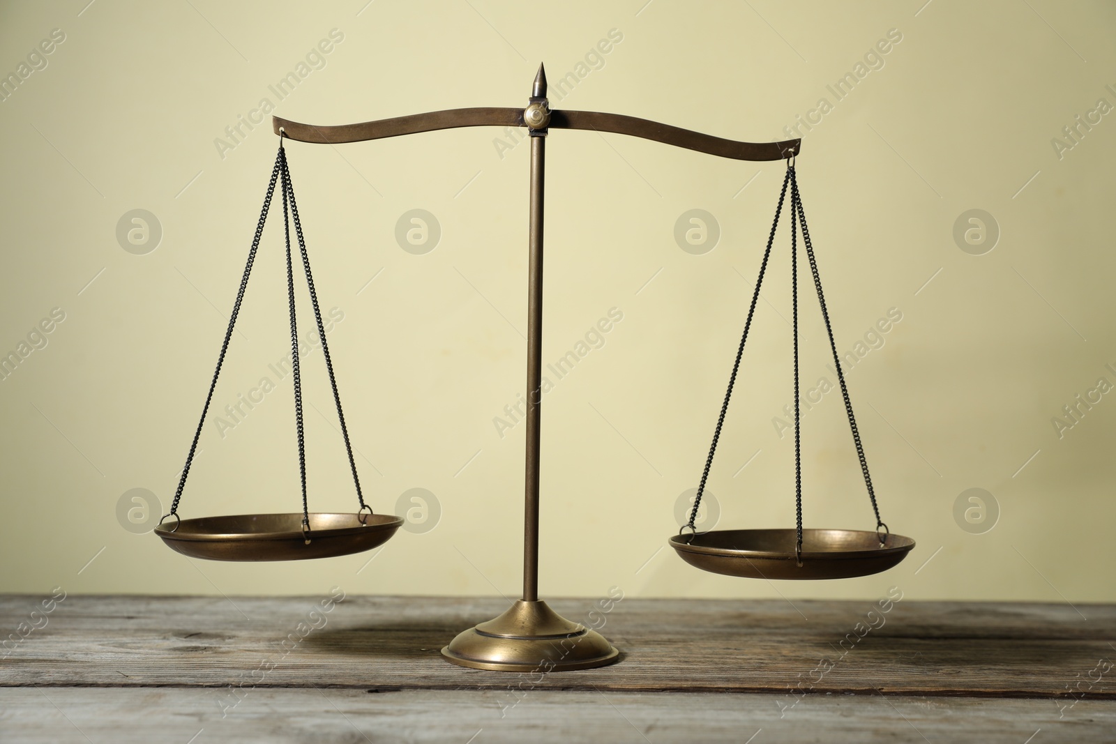 Golden scales of justice on wooden table against beige background Photo of Golden scales of justice on wooden table against beige background