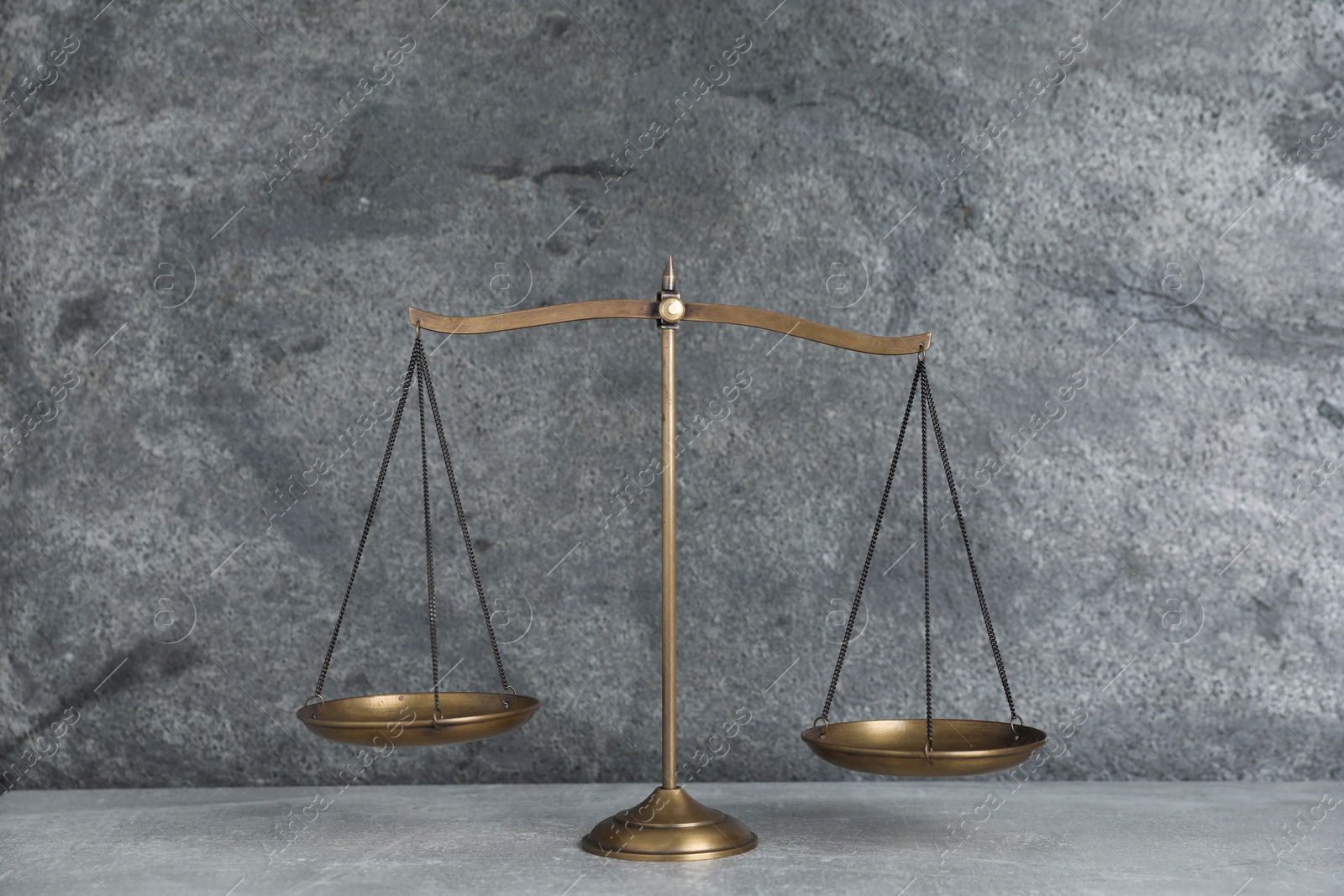 Golden scales of justice on grey table Photo of Golden scales of justice on grey table