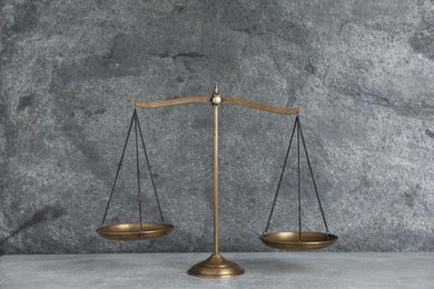 Photo of Golden scales of justice on grey table