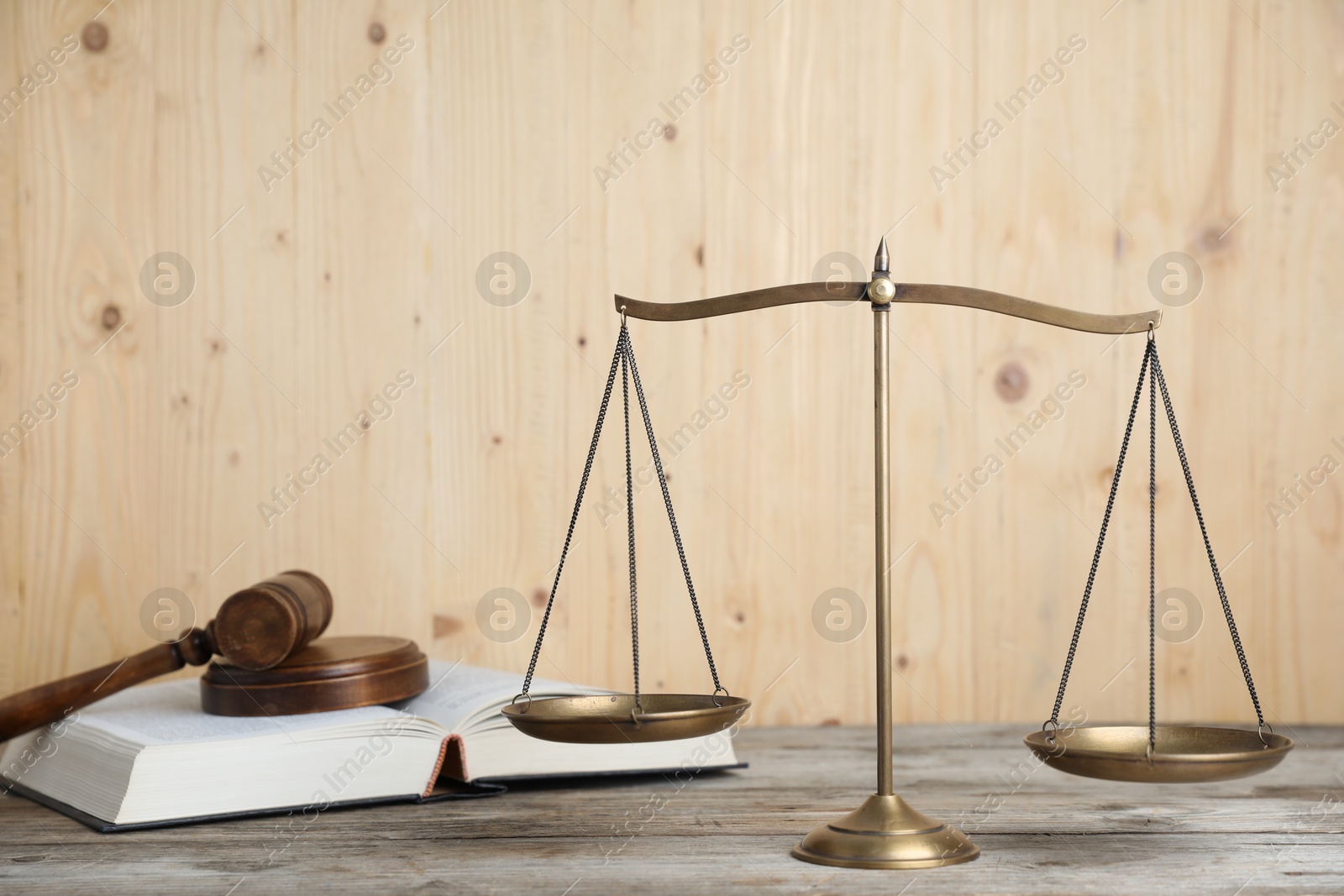 Photo of Golden scales of justice, gavel and book on wooden table