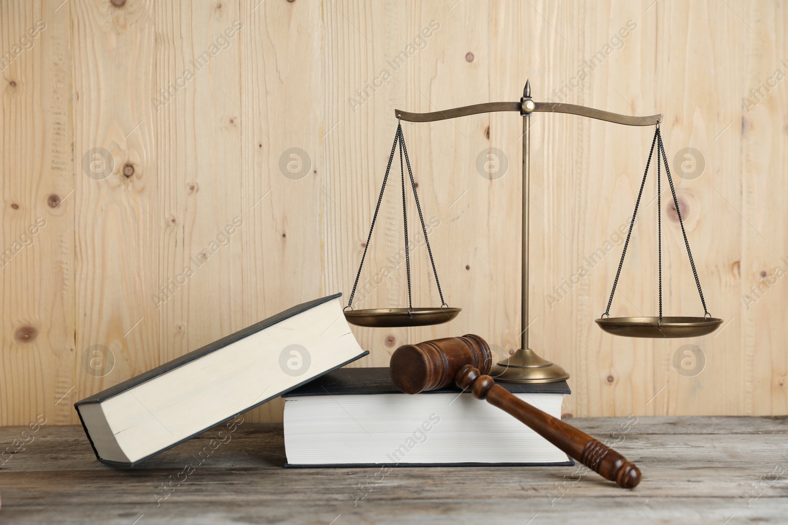 Golden scales of justice, gavel and books on wooden table Photo of Golden scales of justice, gavel and books on wooden table