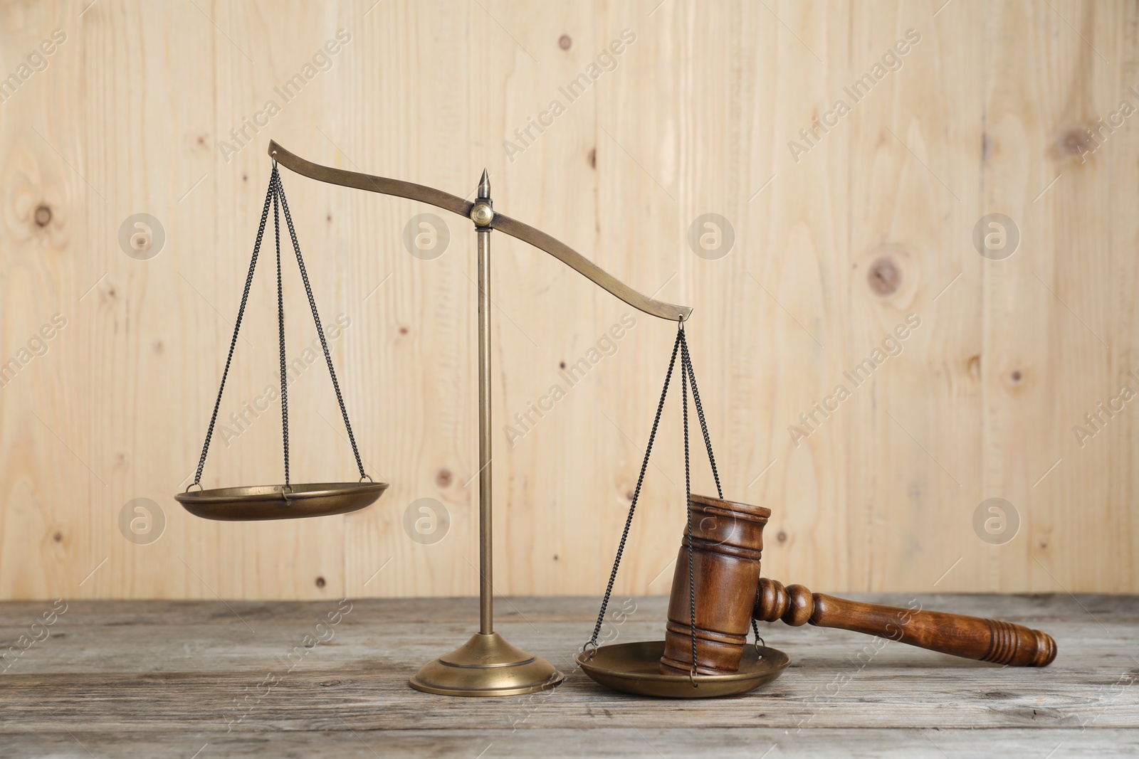 Photo of Golden scales of justice and gavel on wooden table