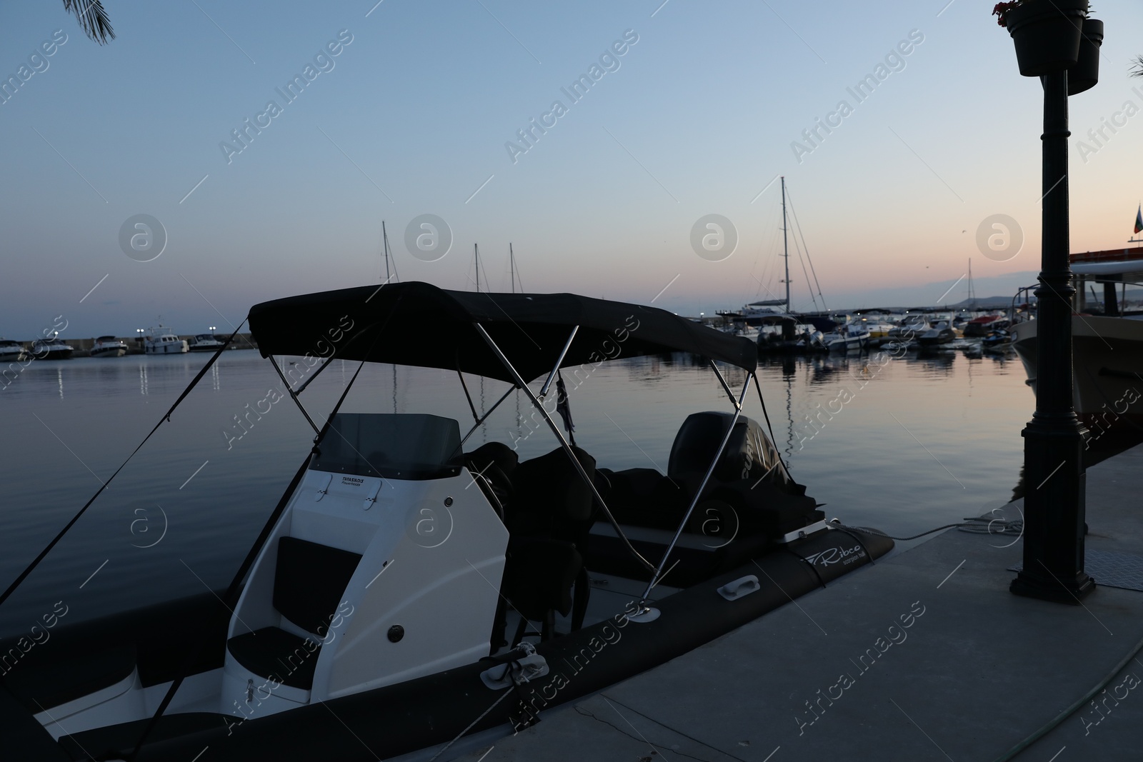 Photo of Sveti Vlas, Bulgaria - July 11, 2025: Moored boat near pier in sea at sunset