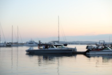 Photo of Moored boats in sea port at sunset, blurred view