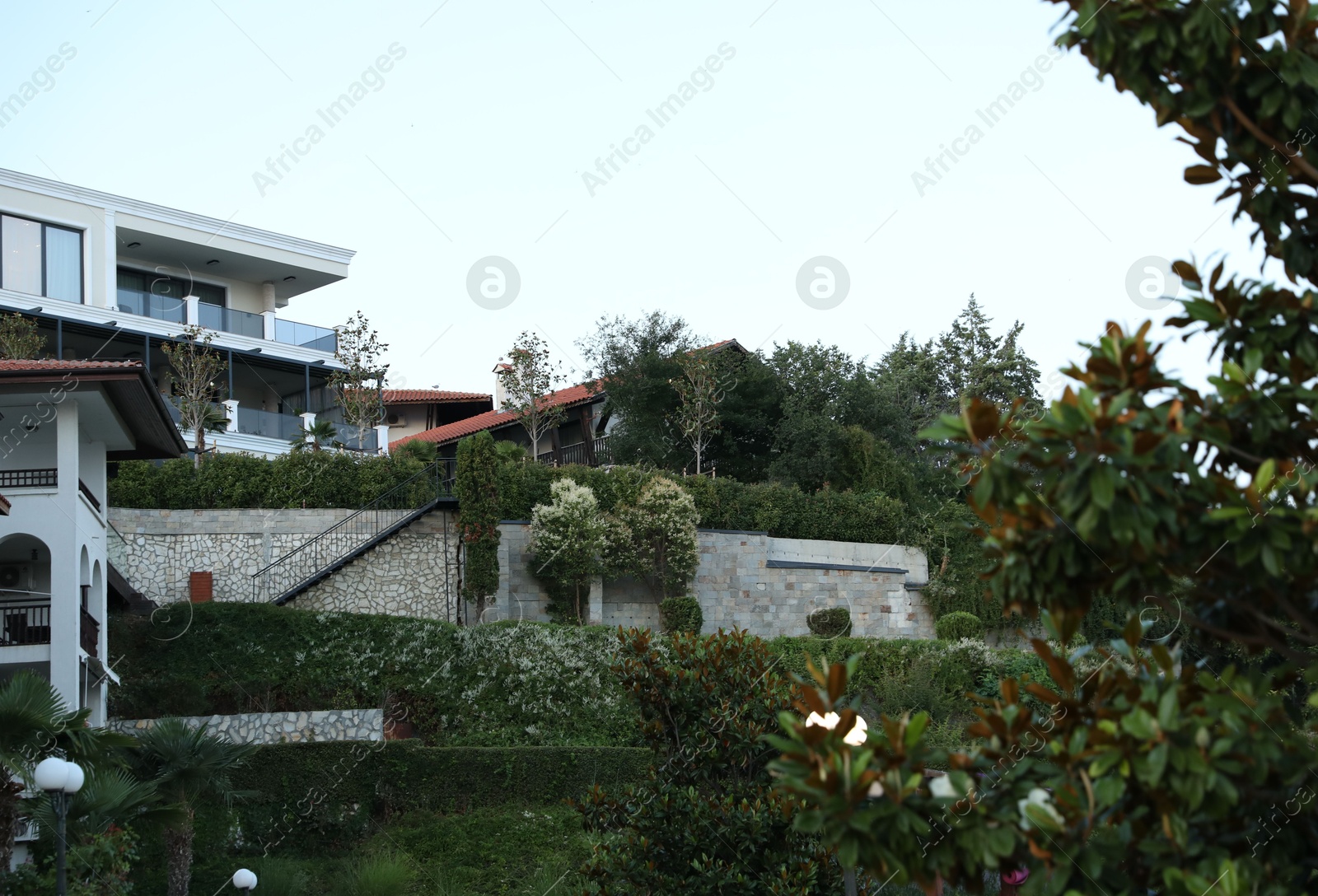 Luxury hotel buildings and green garden outdoors Photo of Luxury hotel buildings and green garden outdoors