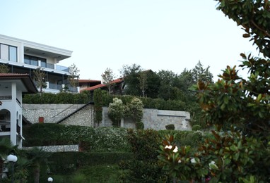 Photo of Luxury hotel buildings and green garden outdoors