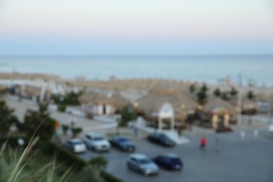 Photo of Luxury area with parked cars in resort near sea at sunset, blurred view