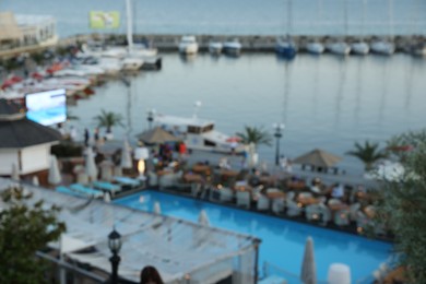 Photo of Luxury resort with swimming pool and outdoor restaurant near sea, blurred view