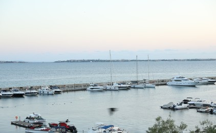 Photo of Sveti Vlas, Bulgaria - July 11, 2025: Moored ferries and boats in sea port at sunset