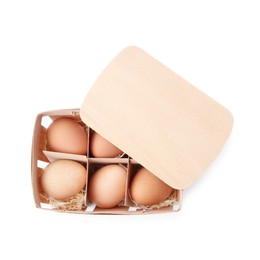 Photo of Raw chicken eggs in wooden egg tray isolated on white, top view