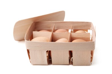 Photo of Raw chicken eggs in wooden egg tray isolated on white
