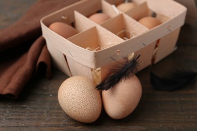 Photo of Raw chicken eggs in egg tray on wooden table, closeup