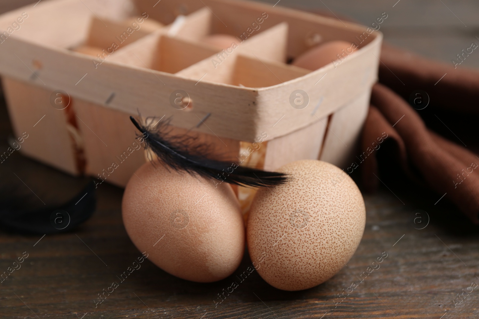 Photo of Raw chicken eggs in egg tray on wooden table, closeup