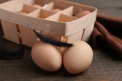 Photo of Raw chicken eggs in egg tray on wooden table, closeup