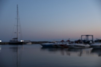 Photo of Moored boats in sea port at sunset, blurred view