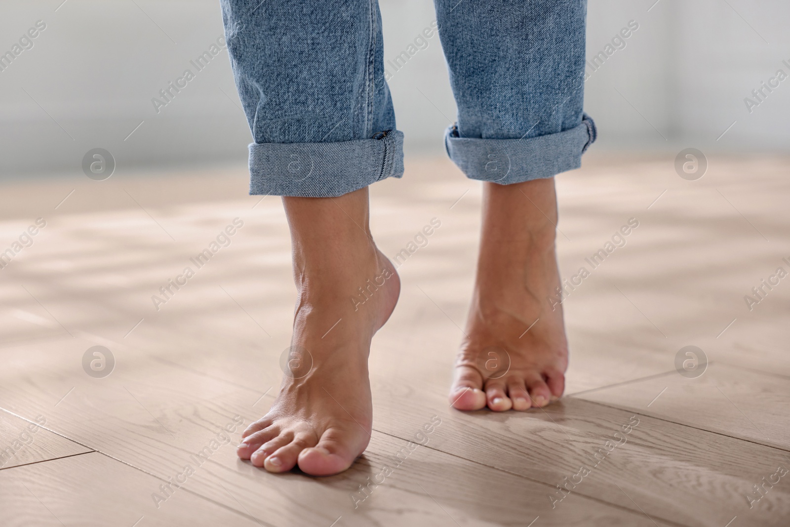 Image of Woman walking barefoot on warm floor indoors, closeup. Underfloor heating