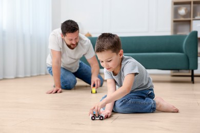 Image of Father and son feeling comfortable to play on warm floor at home. Underfloor heating
