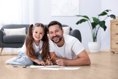 Image of Father and daughter feeling comfortable on warm floor at home. Underfloor heating