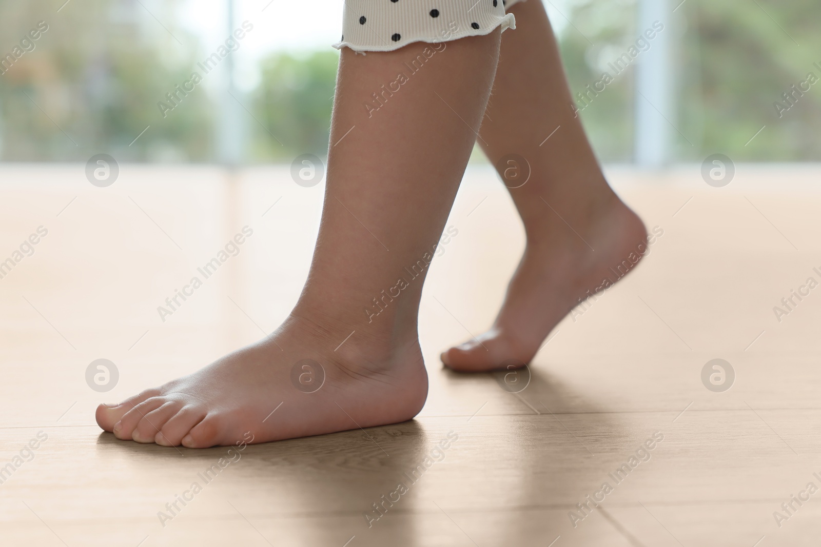 Image of Child walking barefoot on warm floor indoors, closeup. Underfloor heating