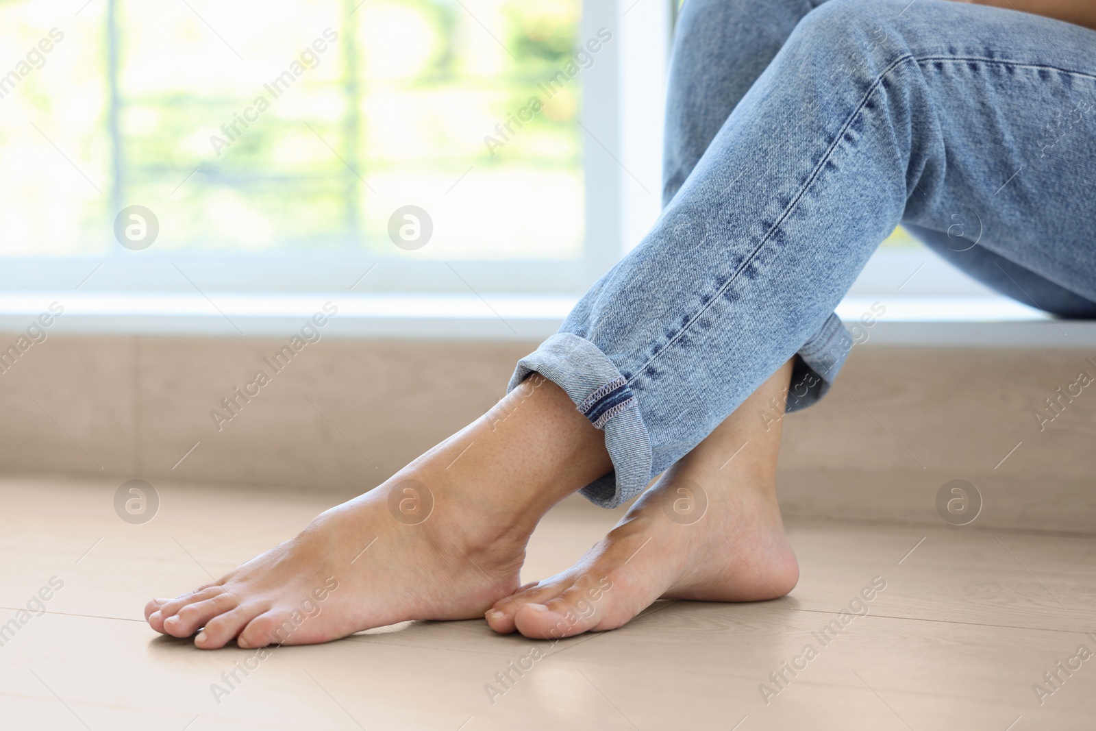 Image of Barefoot woman feeling comfortable on warm floor at home, closeup. Underfloor heating