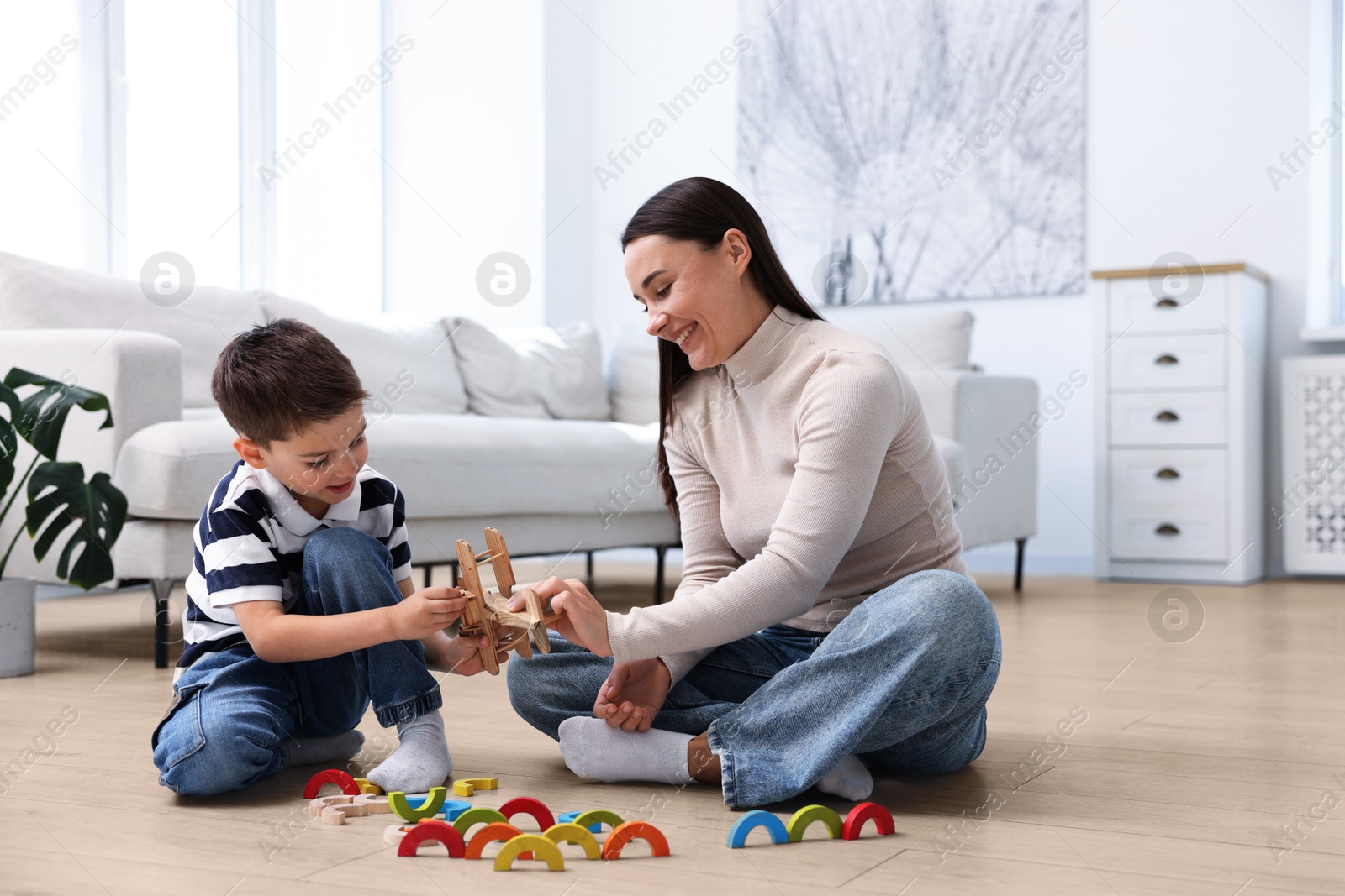 Image of Mother and son feeling comfortable to play together on warm floor at home. Underfloor heating