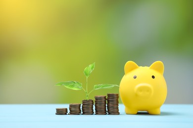 Image of Savings concept. Stacked coins, green sprout and piggy bank on table against blurred background