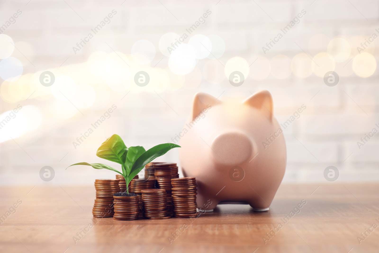 Savings concept. Stacked coins, green sprout and piggy bank on table, bokeh effect Image of Savings concept. Stacked coins, green sprout and piggy bank on table, bokeh effect