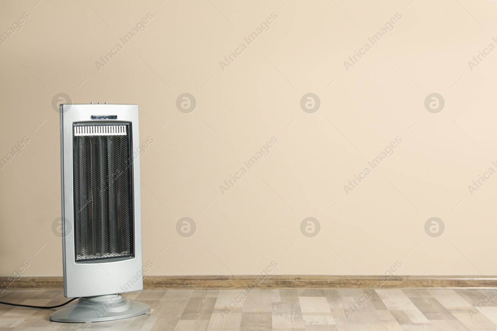 New modern electric heater on floor in room, space for text Photo of New modern electric heater on floor in room, space for text