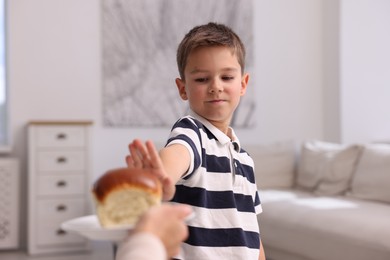 Photo of Gluten free diet. Little boy refusing bun at home
