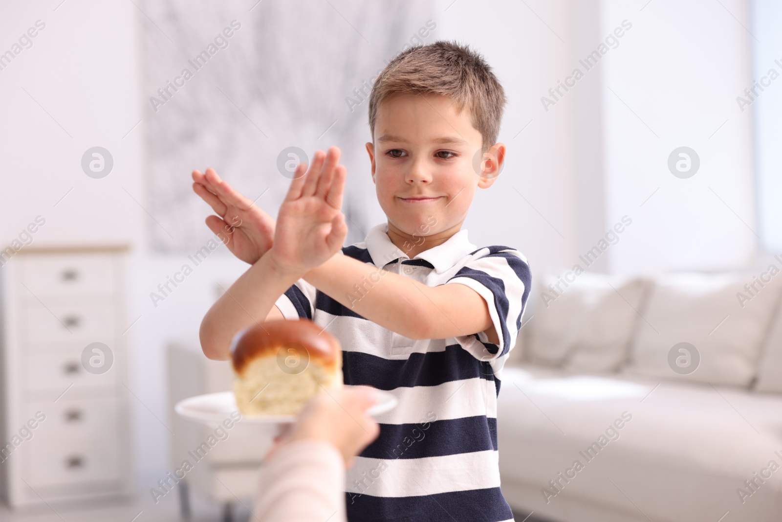 Gluten free diet. Little boy refusing bun at home Photo of Gluten free diet. Little boy refusing bun at home