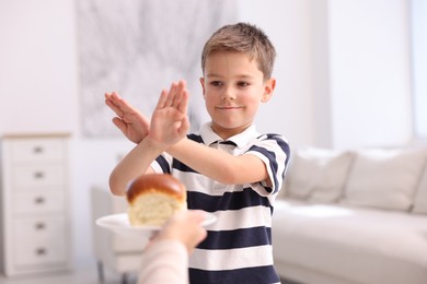 Photo of Gluten free diet. Little boy refusing bun at home
