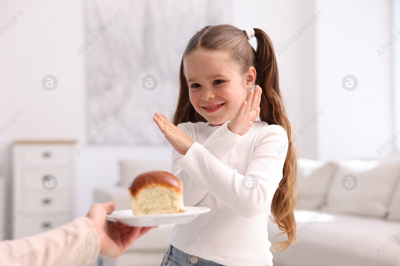 Gluten free diet. Little girl refusing bun at home Photo of Gluten free diet. Little girl refusing bun at home