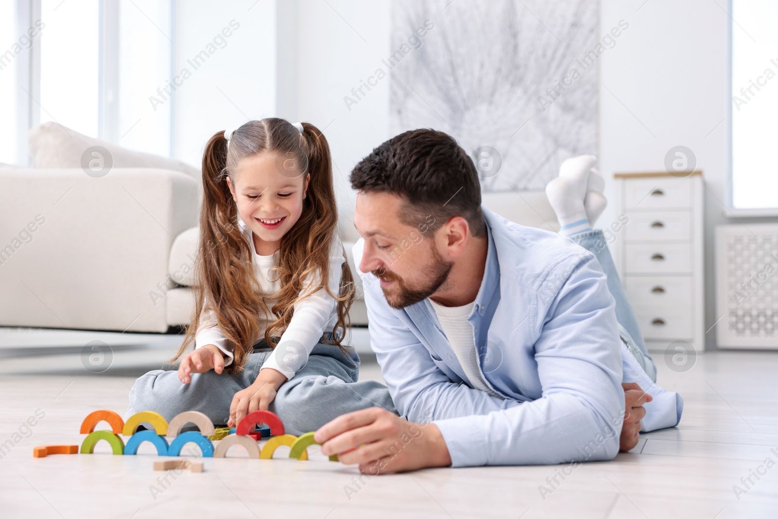 Father and his daughter playing with toys on warm floor at home. Heating system Photo of Father and his daughter playing with toys on warm floor at home. Heating system
