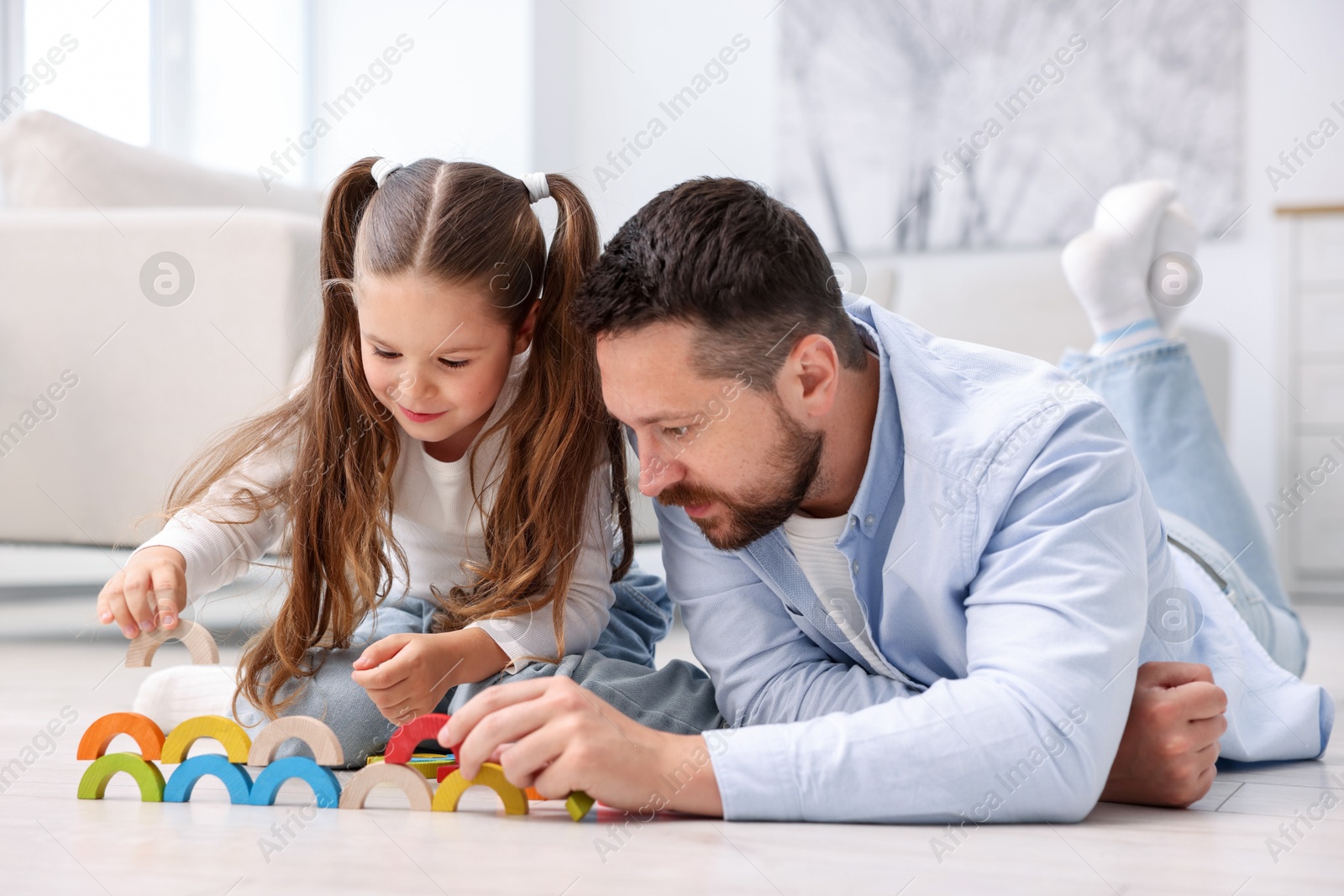 Father and his daughter playing with toys on warm floor at home. Heating system Photo of Father and his daughter playing with toys on warm floor at home. Heating system