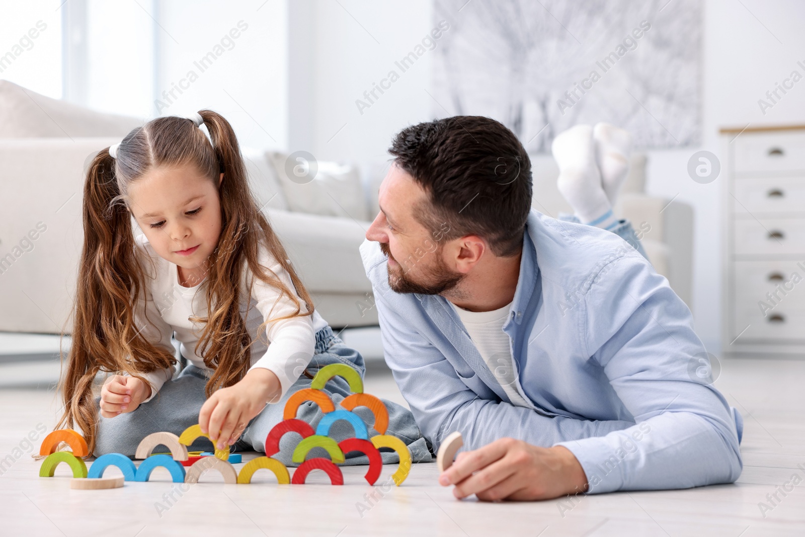 Father and his daughter playing with toys on warm floor at home. Heating system Photo of Father and his daughter playing with toys on warm floor at home. Heating system