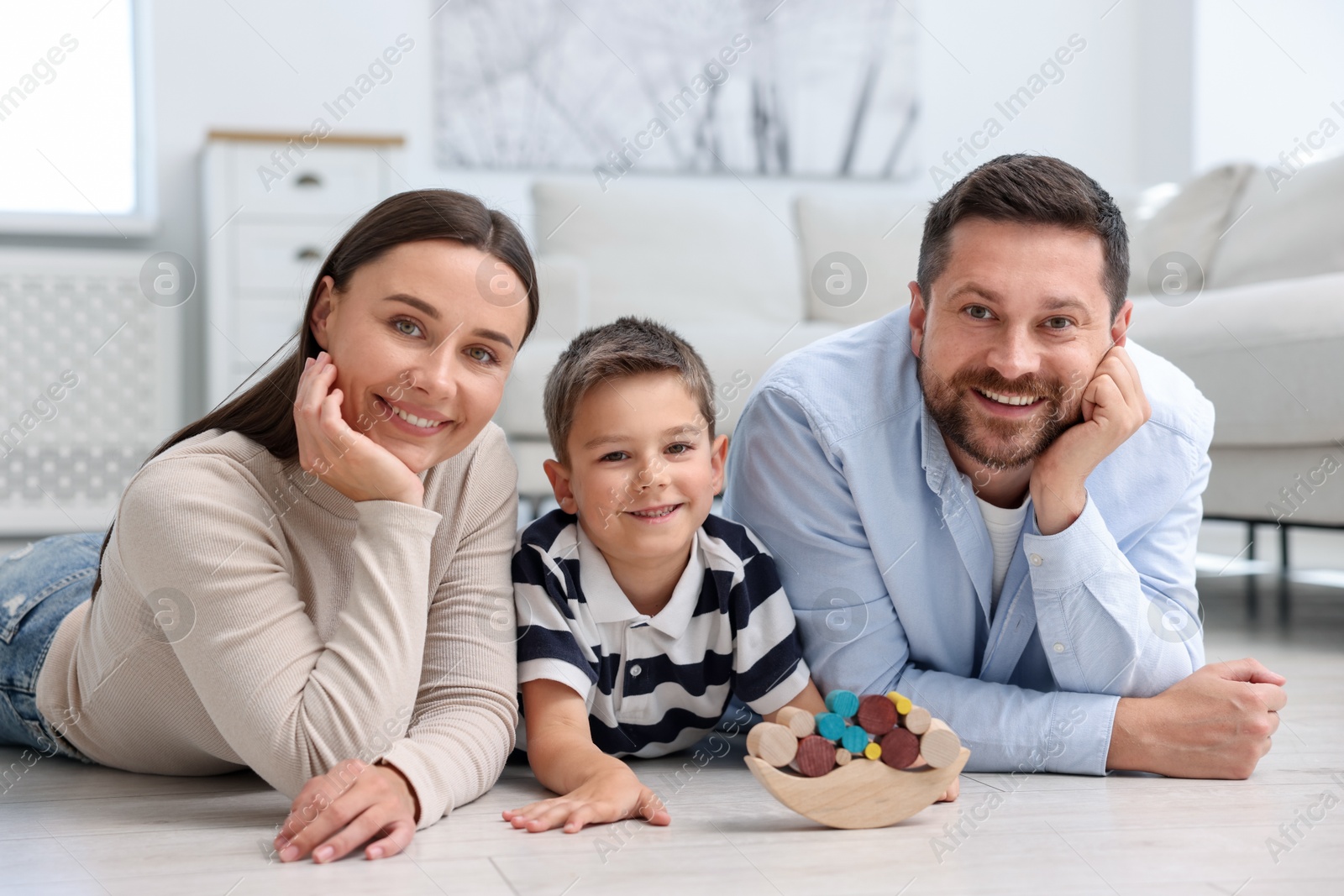 Parents and their son playing with toys on warm floor at home. Heating system Photo of Parents and their son playing with toys on warm floor at home. Heating system