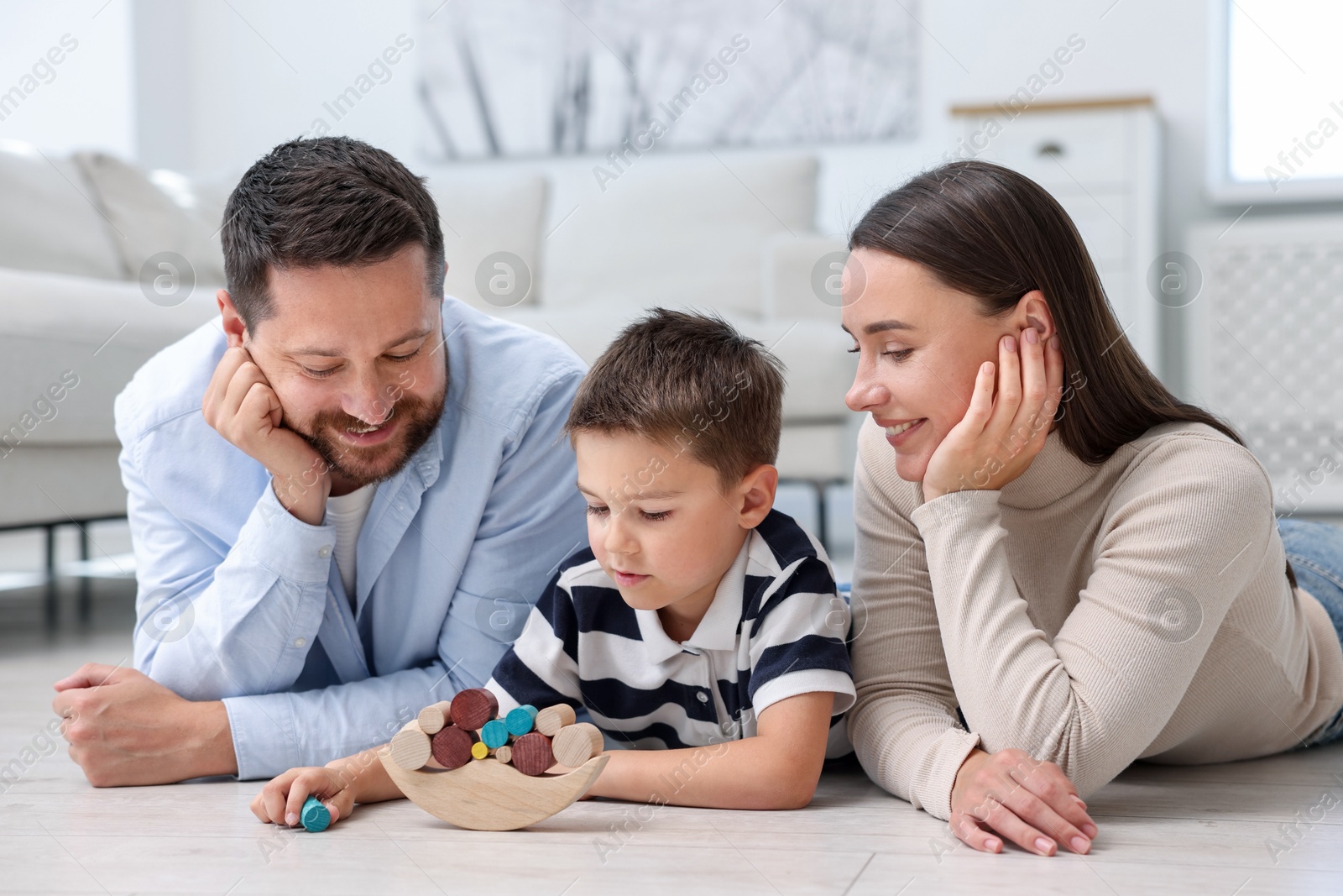 Parents and their son playing with toys on warm floor at home. Heating system Photo of Parents and their son playing with toys on warm floor at home. Heating system