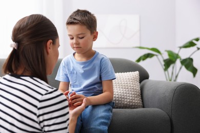 Photo of Mother supporting her sad son on sofa at home, space for text