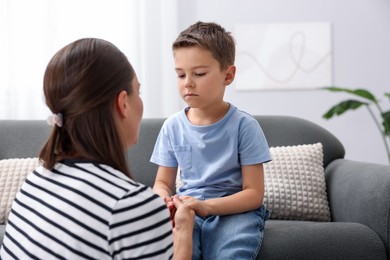 Photo of Mother supporting her sad son on sofa at home, space for text