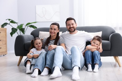 Photo of Parents and their kids together on warm floor at home. Heating system