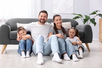 Photo of Parents and their kids together on warm floor at home. Heating system